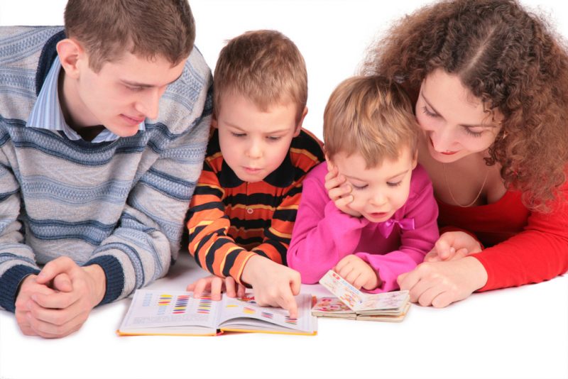 дети и родители читают книгу для викторины